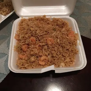 a takeout container of rice and shrimp