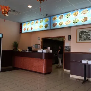 a chinese restaurant with a large menu on the wall