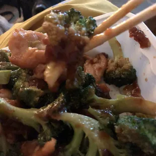 a plate of broccoli with chopsticks