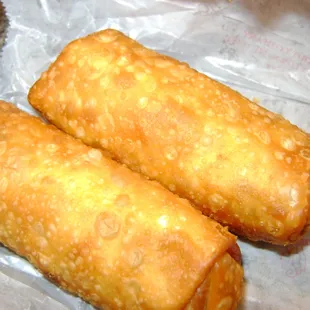 two fried bread rolls on a piece of wax paper