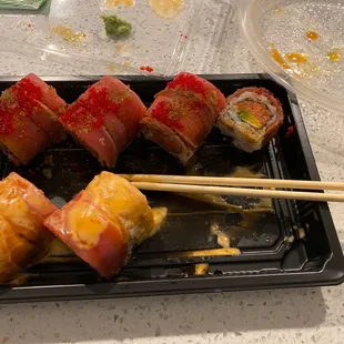a tray of sushi and chopsticks