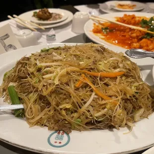 a plate of noodles with meat and veggies