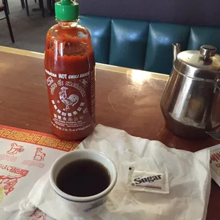 a hot sauce and a cup of coffee