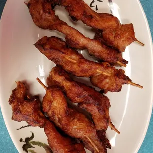 a plate of pork skewers