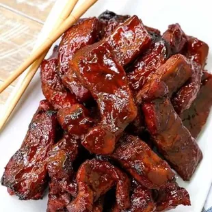 a plate of meat and chopsticks