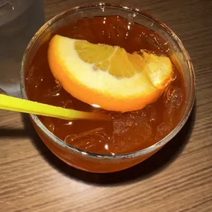 an orange slice in a glass of tea