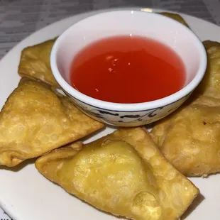 a plate of fried pastries and a bowl of sauce
