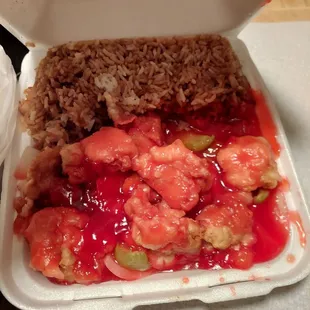 a takeout box with rice, meat, and vegetables