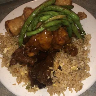 a plate of rice, meat, and green beans