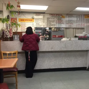 a woman standing at a counter in a restaurant