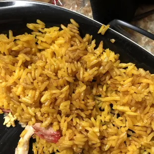 a plate of yellow rice and chicken