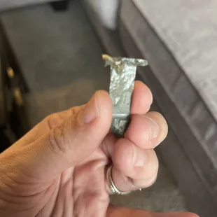 a hand holding a piece of aluminum foil