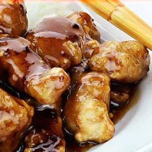 a plate of chicken and rice with chopsticks