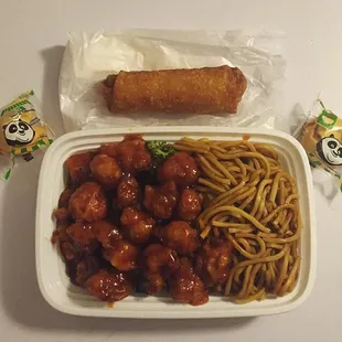 a plate of noodles, meatballs, and a roll