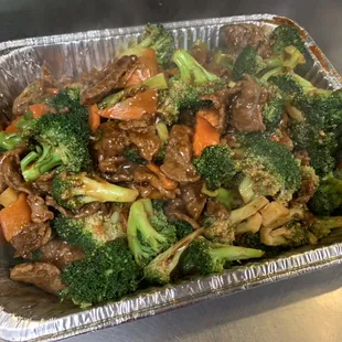 beef and broccoli in a foil container