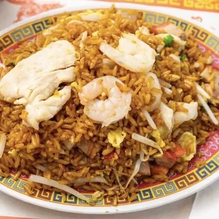 a plate of fried rice with shrimp and vegetables