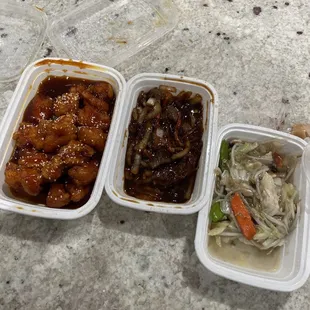 three containers of food sitting on a counter