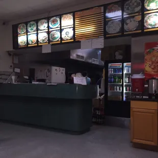 a restaurant with a counter and seating area