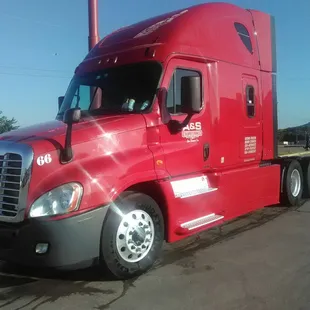a red semi truck parked in a parking lot