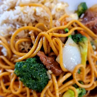 a plate of noodles with meat and broccoli