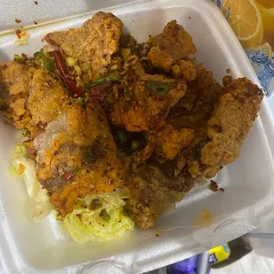 a takeout container of fried chicken