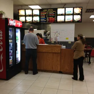 a man and a woman ordering food at a fast food restaurant