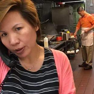a woman talking on a phone in a kitchen