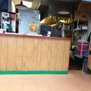 a man behind a counter in a restaurant