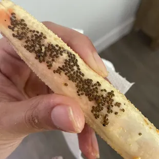 a person holding a banana with seeds on it