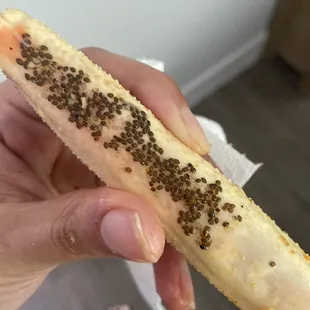 a person holding a banana with seeds on it