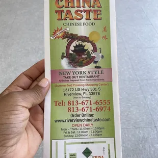 a hand holding a chinese food menu