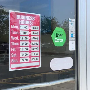 a business hours sign in a window