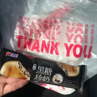 a hand holding a bag of donuts