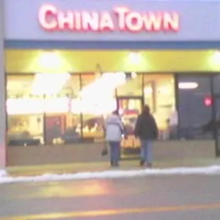 two people walking in front of a store