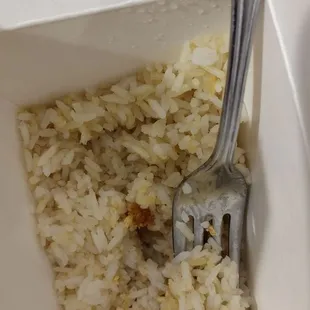 a fork stuck in a bowl of rice
