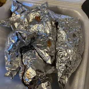 a tray of food wrapped in aluminum foil