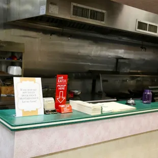 a kitchen counter with a sign on it