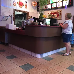 a woman standing at a counter in a restaurant