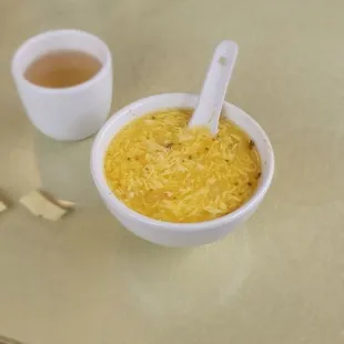 a bowl of soup and two cups of tea
