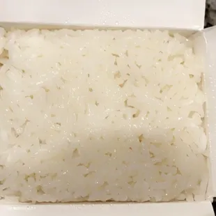 rice in a white box with chopsticks