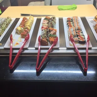 a row of sushi rolls with chopsticks