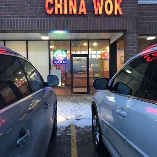two cars parked in front of a chinese restaurant