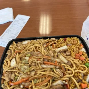 noodles and vegetables in a black container