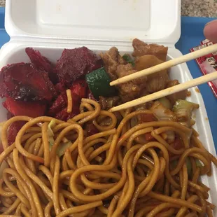 chopsticks and noodles in a styrofoam container