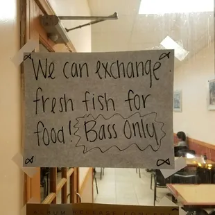a sign that reads we can exchange fresh fish for food bass only