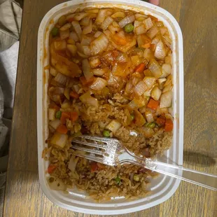 a person holding a fork in a container of food