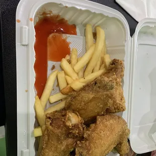 fried chicken and french fries in a styrofoam container