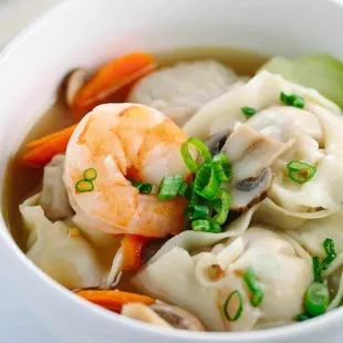 a bowl of soup with shrimp and carrots