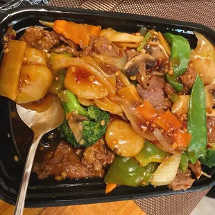 beef, broccoli, and peppers in a black container