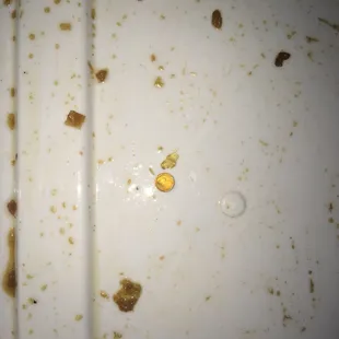 a yellow pill on a dirty plate